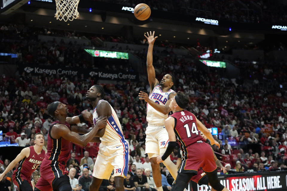 Philadelphia 76ers guard De'Anthony Melton, center right, shoots as Miami Heat guard Tyler Herro (14) defends during the first half of an NBA basketball game, Monday, Dec. 25, 2023, in Miami. (AP Photo/Lynne Sladky)