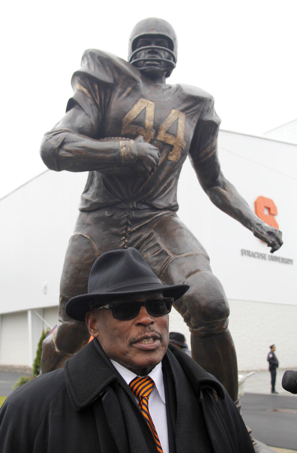 FILE - In this Nov. 14, 2015 file photo, Floyd Little, stands next to a statue of himself dedicated during a ceremony on the Syracuse University campus in Syracuse, N.Y. Little, the Hall of Fame running back who starred at Syracuse and for the Denver Broncos, has died. The Pro Football Hall of Fame said he died Friday, Jan. 1, 2021. (AP Photo/Nick Lisi)