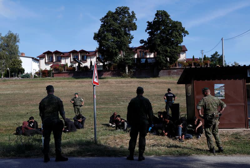 Migrants wait, as they are detained by Slovakian police, after illegally crossing the border close to the Slovakia-Hungary border in the village of Chl'aba