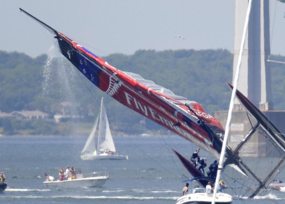 Team New Zealand crew members hang on as they attempt to right their ship after their boat capsized during a match race at the first day of the America's Cup World Series regatta in Newport, R.I., Thursday, June 28, 2012. (AP Photo/Stephan Savoia)