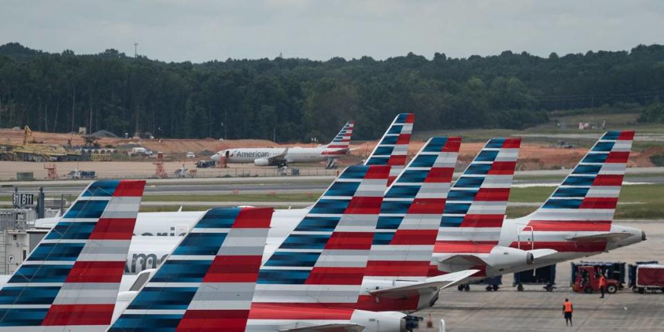 A row of American Airlines jets sit on the tarmac, as seen from the seventh-floor roof of the hourly parking structure at Charlotte Douglas International Airport on Friday morning, July 1, 2022.