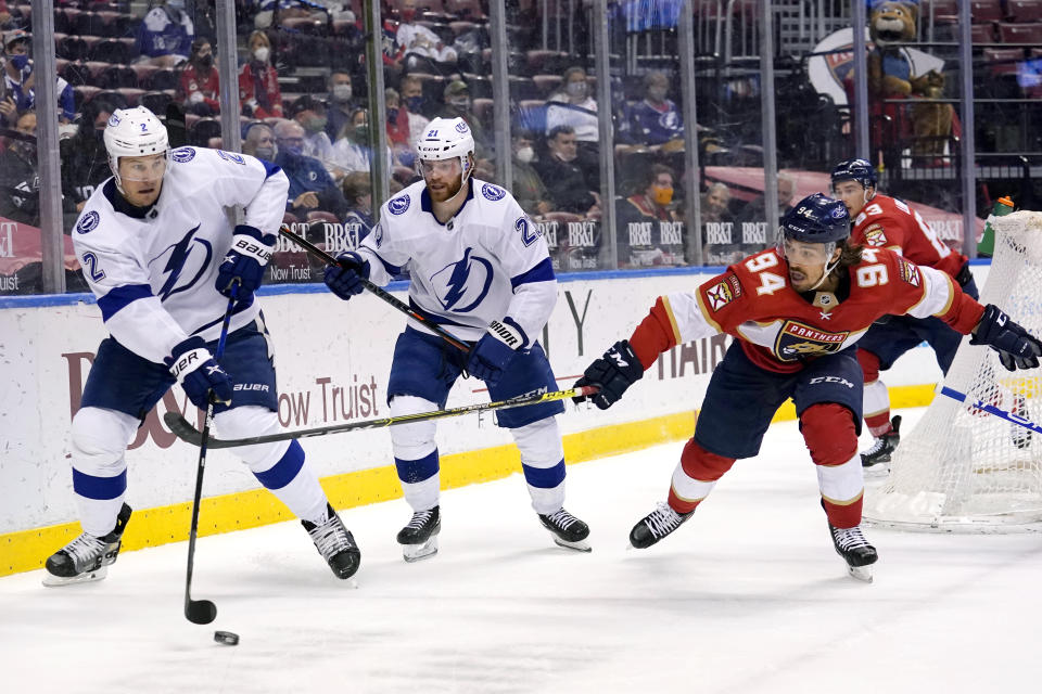 Tampa Bay Lightning defenseman Luke Schenn, left, passes the puck as Florida Panthers left wing Ryan Lomberg, right, defends during the second period of an NHL hockey game, Monday, May 10, 2021, in Sunrise, Fla. (AP Photo/Lynne Sladky)