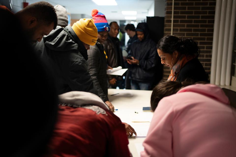 Rupal Ramesh Shah, right, with the Community Shelter Board, collects information from residents of Colonial Village who have been told they have to leave by Dec. 31, during a community meeting held by the city to discuss the relocation of 508 units.