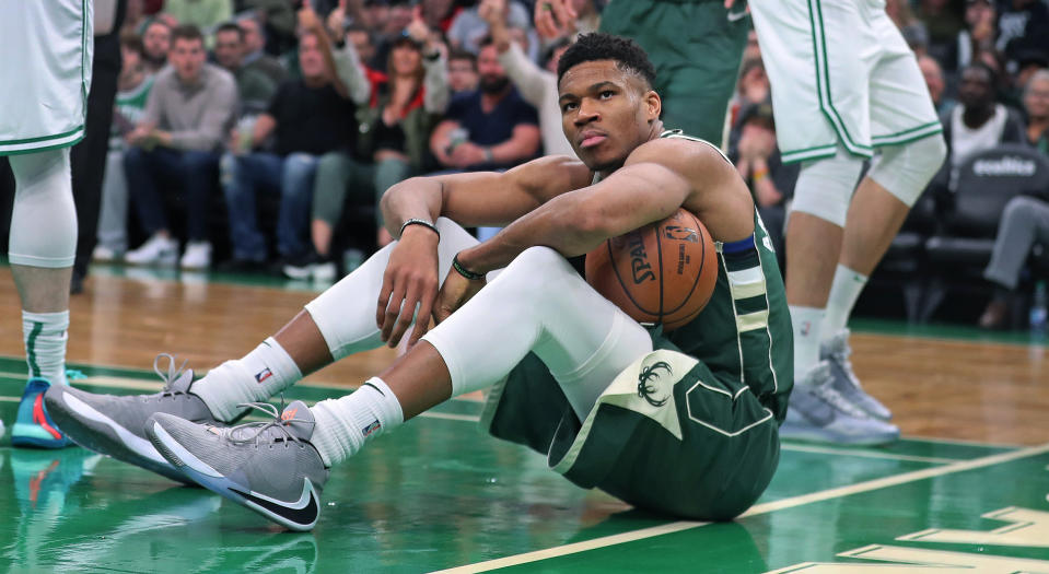 BOSTON - OCTOBER 30: Milwaukee Bucks' Giannis Antetokounmpo (34) reacts on the floor after he was called for an offensive foul on a drive against the Celtics' Marcus Smart (36), who high-fives with teammate Daniel Theis at far right. The Boston Celtics host the Milwaukee Bucks in a regular season NBA basketball game at TD Garden in Boston on Oct. 30, 2019. (Photo by Jim Davis/The Boston Globe via Getty Images)