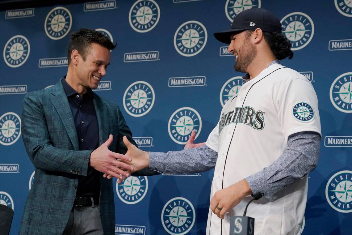Jerry Dipoto, left, Seattle Mariners President of Baseball Operations, shakes hands with new Seattle Mariners pitcher Robbie Ray, right, Wednesday, Dec. 1, 2021, during a news conference in Seattle. The AL Cy Young Award winner — who previously pitched for the Toronto Blue Jays — signed a five-year contract with the Mariners. (AP Photo/Ted S. Warren)