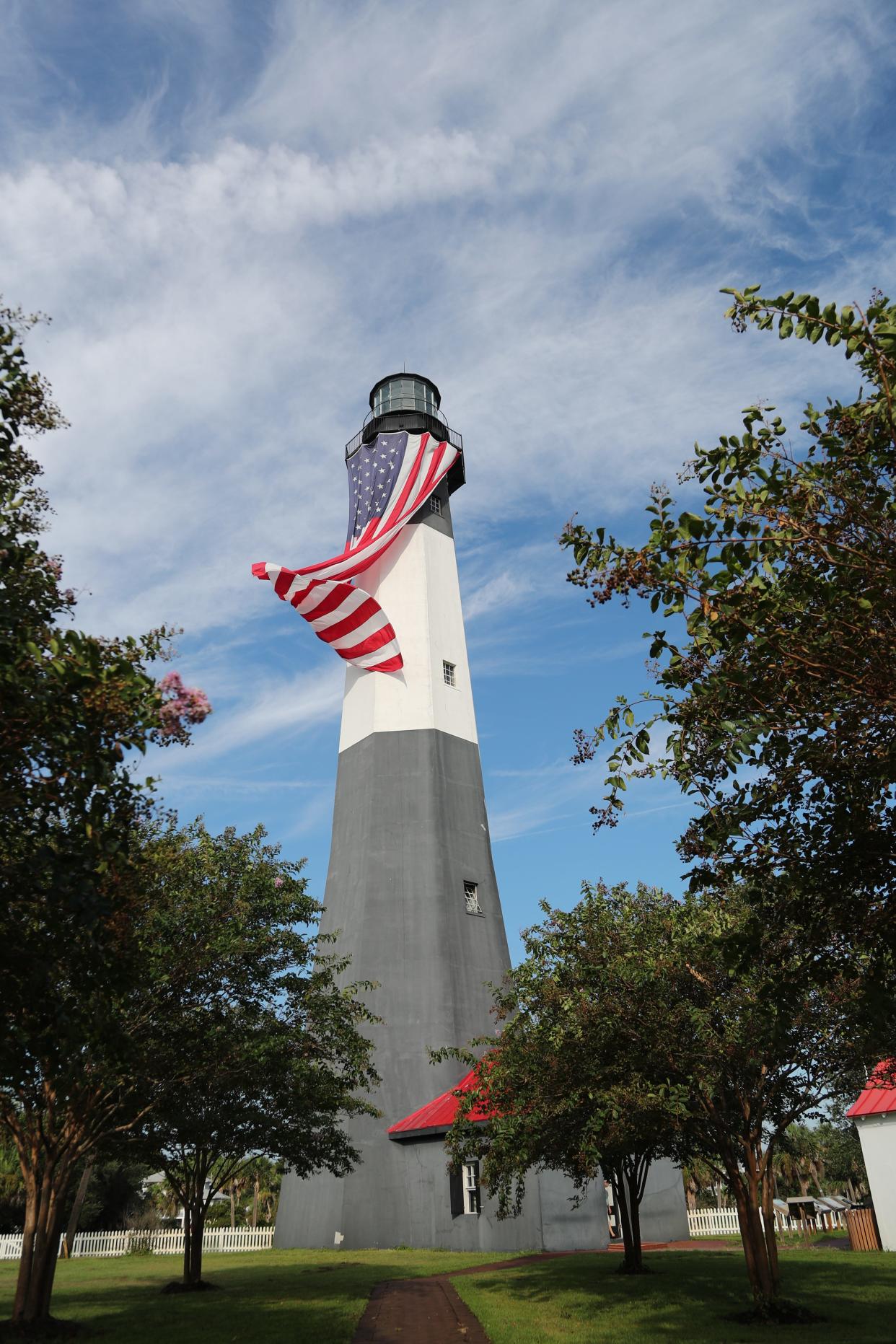 The giant 30-by-60 foot American Flag flies in the breeze from the railing of the Tybee Island Lighthouse on Monday, September 11, 2023.