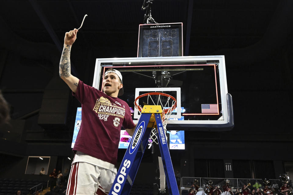 Charleston guard Reyne Smith cuts down the nets after defeating Stony Brook in the NCAA college basketball game in the championship of the Coastal Athletic Association conference tournament, Tuesday, March 12, 2024, in Washington. (AP Photo/Terrance Williams)