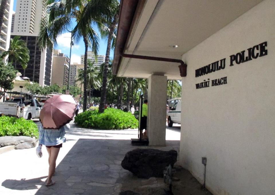 A pedestrian walks in front of a Honolulu Police Department station in Honolulu's tourist area of Waikiki on Wednesday, March 19, 2014. As Hawaii lawmakers considered a measure that would crack down on prostitution, the Honolulu Police Department requested a change that has shocked human trafficking experts and victims rights advocates: Police wanted it to remain legal for undercover officers to have sex with prostitutes. (AP Photo/Oskar Garcia)