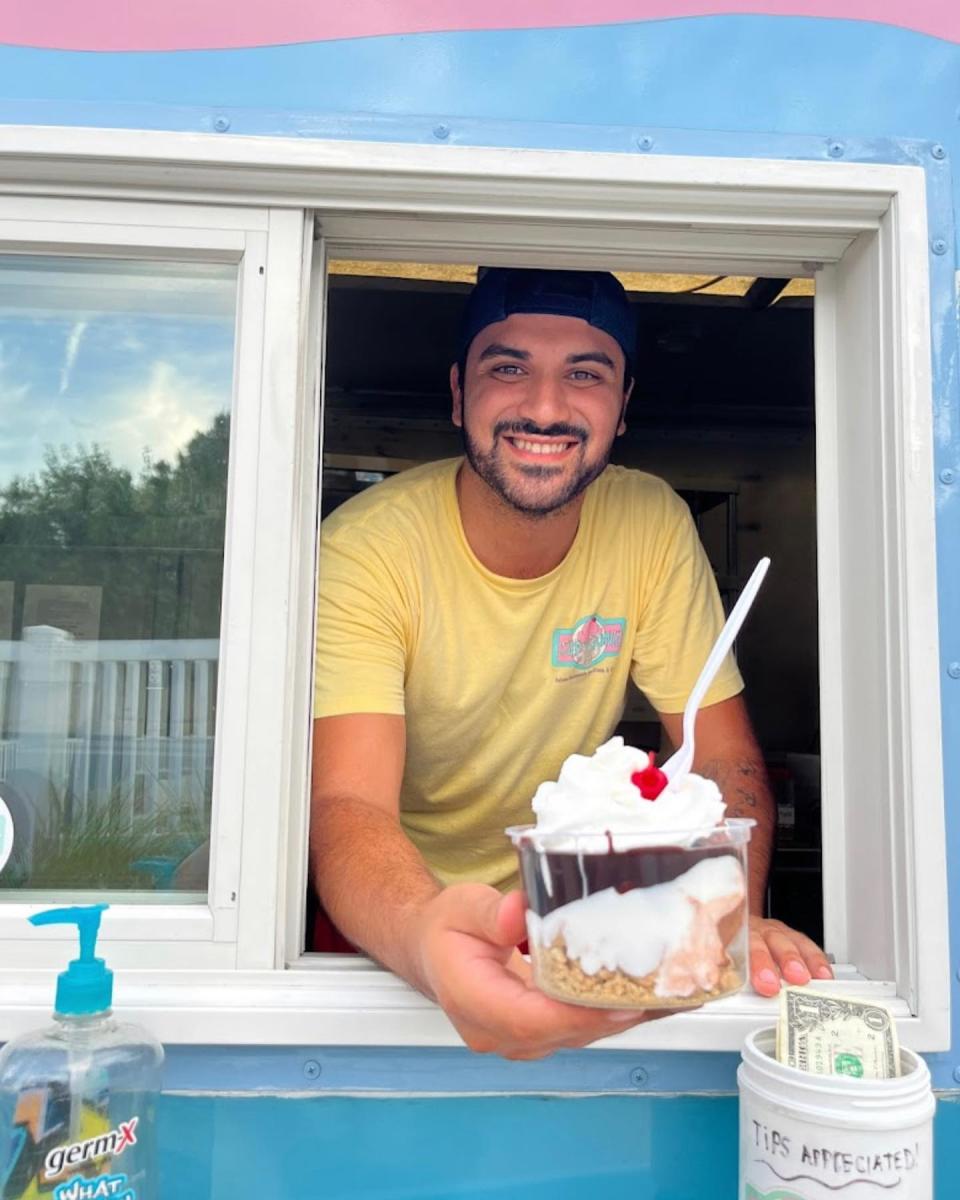 Vince Failla offers a sundae from the window of his Cup 'r Cone ice cream truck.