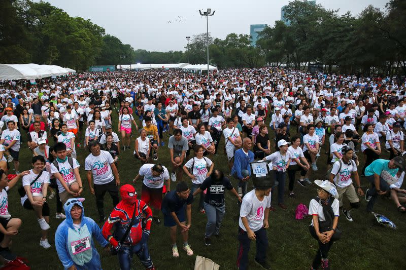 Runners warm up as they attend the "Run Against Dictatorship" event at a Public park in Bangkok