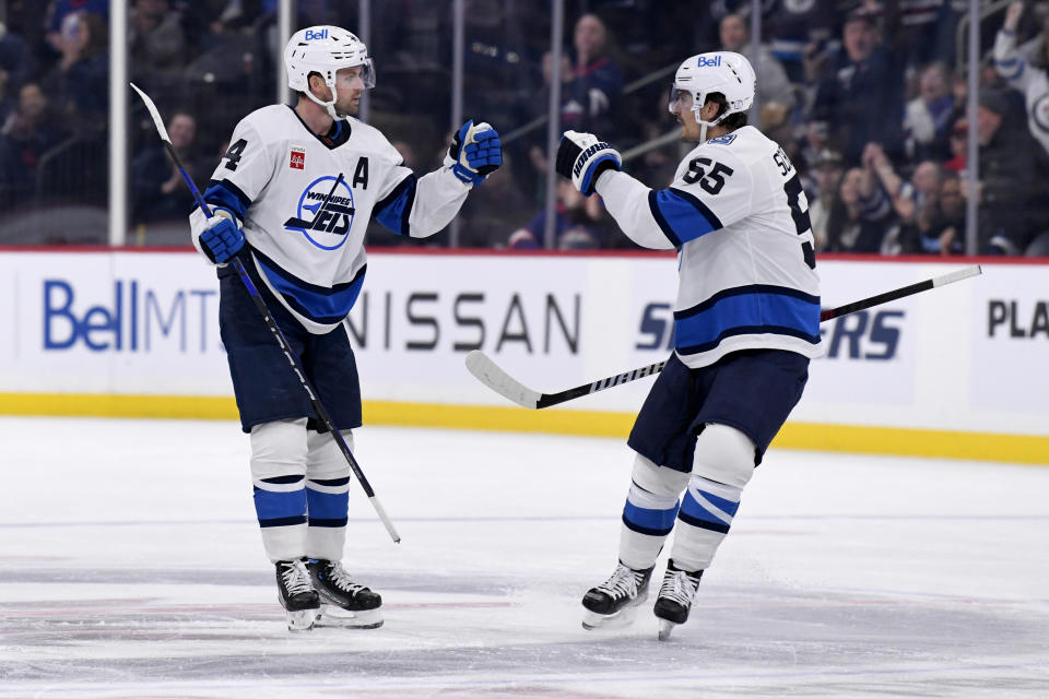 Winnipeg Jets' Josh Morrissey (44) celebrates his goal against the Chicago Blackhawks with Mark Scheifele (55) during the second period of NHL hockey game action in Winnipeg, Manitoba, Saturday, Nov. 5, 2022. (Fred Greenslade/The Canadian Press via AP)