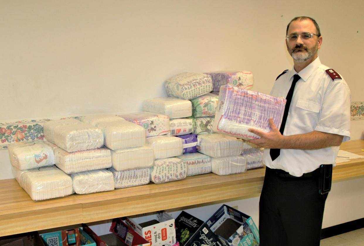 Capt. Jason Price of the Salvation Army Marion, Ohio Corps. holds a pack of diapers and baby wipes that will be distributed to one of the families who registered for the diaper bank operated by the Salvation Army. The agency has been operating the Dry Bottoms Diaper Bank for the past two months in an effort to help families in need.