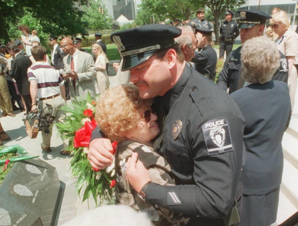 Lila Griffin, mother of slain Charlotte Police officer Eugene Griffin gets a hug from Officer D. J. Offnick at the Police Memorial near the Law Enforcement Center. BOB PADGETT