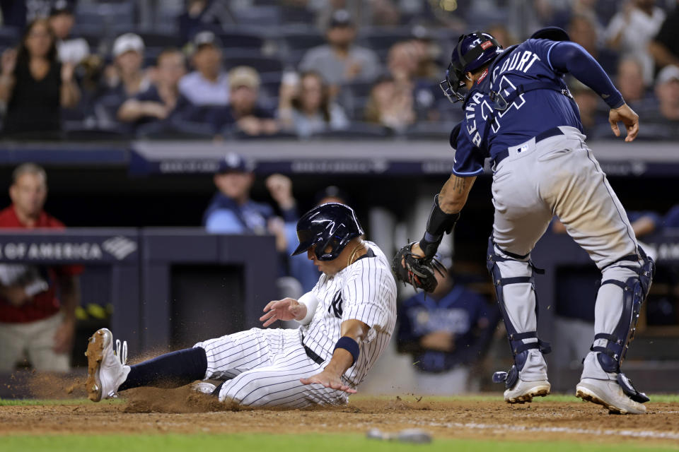 New York Yankees' Oswald Peraza scores a run past Tampa Bay Rays catcher Christian Bethancourt during the seventh inning of a baseball game Friday, Sept. 9, 2022, in New York. (AP Photo/Adam Hunger)