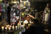 A man touches a statue of Jesus Malverde inside the shrine dedicated to the patron saint of drug dealers in Culiacan, Sinaloa state, Mexico, Thursday, April 8, 2021. Jesus Malverde is worshipped by many drug traffickers in this region which is also known as the cradle of drug trafficking in the country. (AP Photo/Eduardo Verdugo)