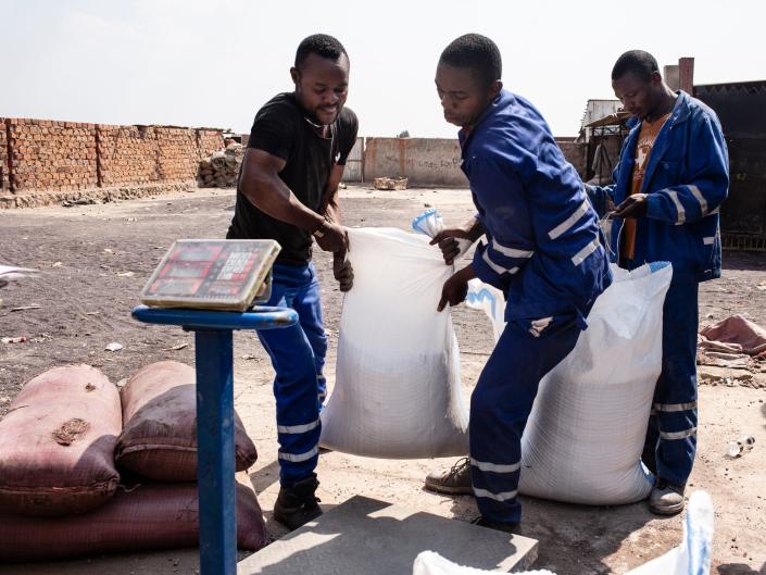 Miners weigh bags of cobalt at a depot