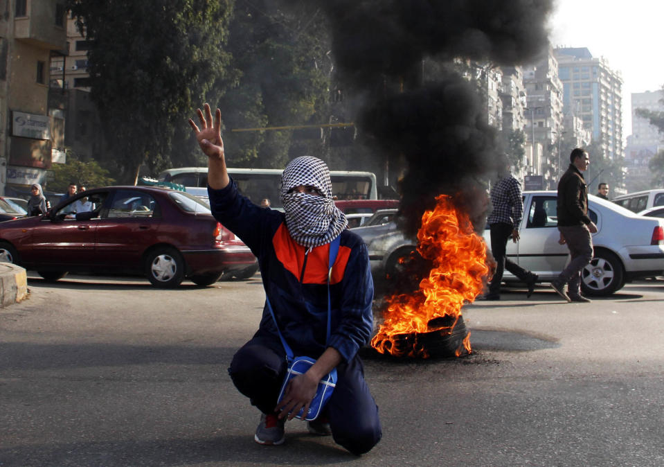 A supporter of ousted leader Mohammed Morsi flashes the "Rabaa" sign during a protest in Nahda Square, near Cairo University in Giza, Egypt, Sunday, Jan. 12, 2014. With a presidential run by Egypt’s powerful military chief seeming more likely by the day, this week’s two-day constitution referendum, to be held amid a massive security force deployment, is widely seen as a vote of confidence in the regime he installed last summer. (AP Photo/Heba Elkholy)