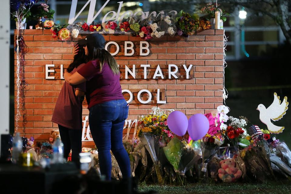 People grieve at a memorial at Robb Elementary School on May 25, 2022. The day before, 19 children and two adults died in the deadliest school shooting in the state's history.