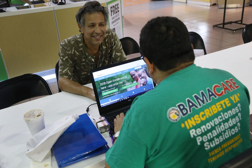 MIAMI, FL - NOVEMBER 01: Rudy Figueroa (R), an insurance agent from Sunshine Life and Health Advisors, speaks with Marvin Mojica as he shops for insurance under the Affordable Care Act at a store setup in the Mall of Americas  on November 1, 2017 in Miami, Florida. The open enrollment period to sign up for a health plan under the Affordable Care Act started today and runs until Dec. 15.  (Photo by Joe Raedle/Getty Images)