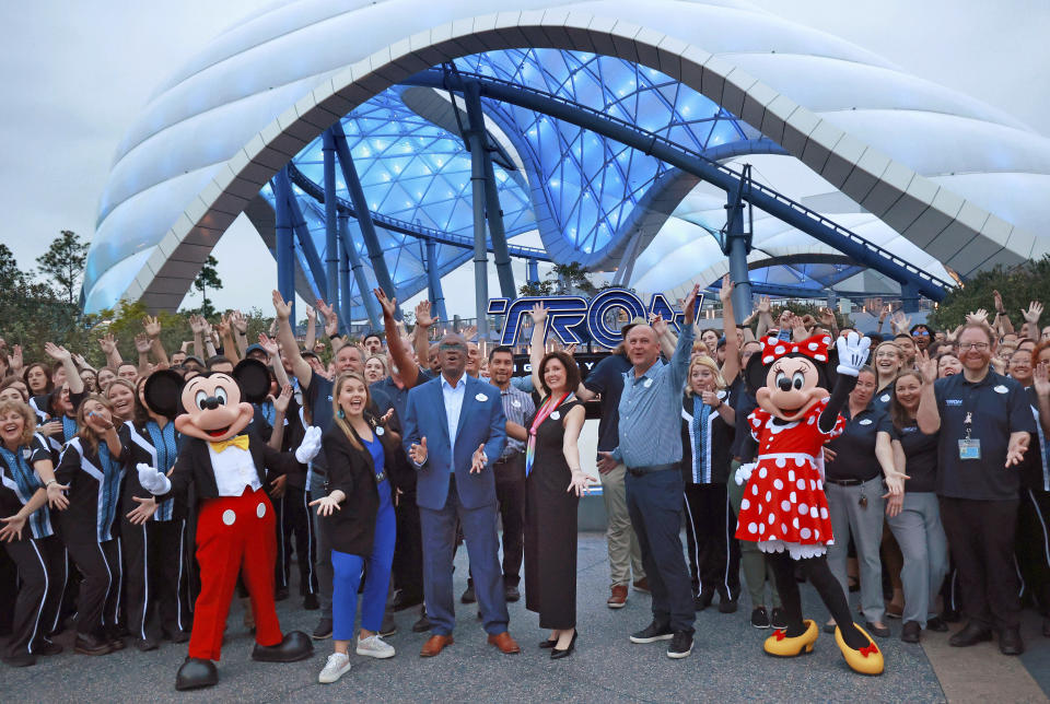 Mickey, Minnie and cast members join Walt Disney World executives in a ceremony marking the official opening of Tron Lightcycle / Run at the Magic Kingdom in Lake Buena Vista, Fla., on Monday, April 3, 2023. The roller coaster opens to guests on Tuesday. From left are Mickey Mouse; Ali Manion, Walt Disney World ambassador; Perry Crawley, Magic Kingdom operations general manager; Melissa Valiquette, vice president of Magic Kingdom; Jason Kirk, senior vice president of operations for Walt Disney World, Minnie Mouse. (Joe Burbank/Orlando Sentinel via AP)