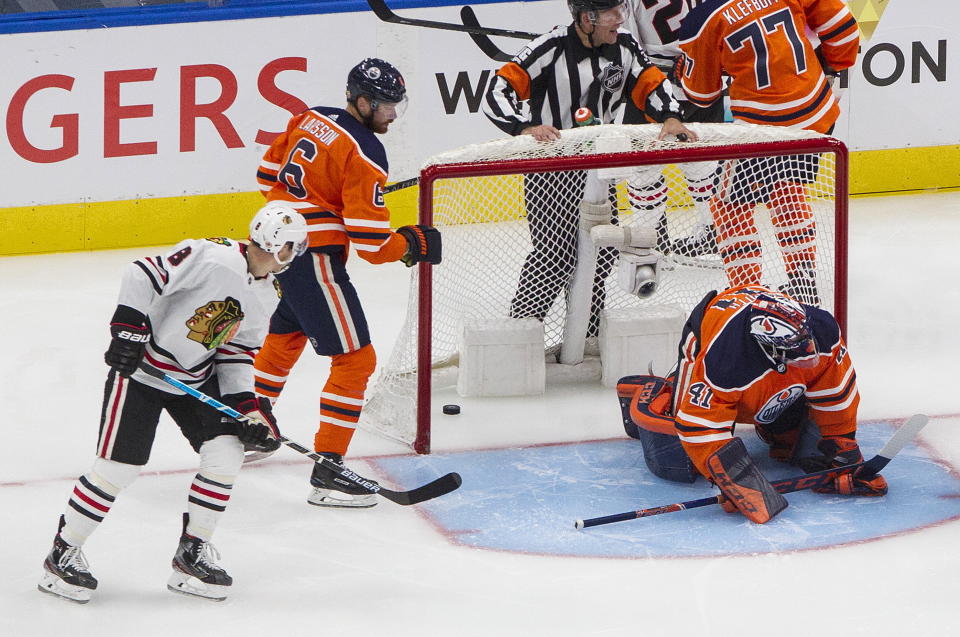 Edmonton Oilers goalie Mike Smith (41) gives up a goal as Adam Larsson (6) and Chicago Blackhawks' Dominik Kubalik (8) look for the puck during the second period of an NHL hockey playoff game in Edmonton, Alberta, Saturday, Aug. 1, 2020. (Jason Franson/The Canadian Press via AP)