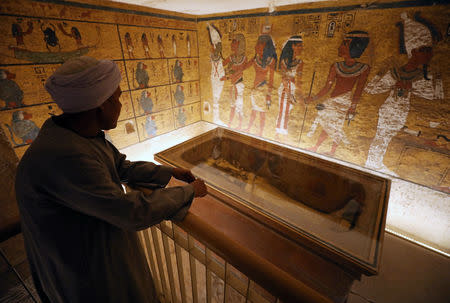 A guard looks at ancient Egyptian drawings and the sarcophagus in the newly renovated tomb wall of boy pharaoh King Tutankhamun in the Valley of the Kings in Luxor, Egypt January 31, 2019. REUTERS/Mohamed Abd El Ghany