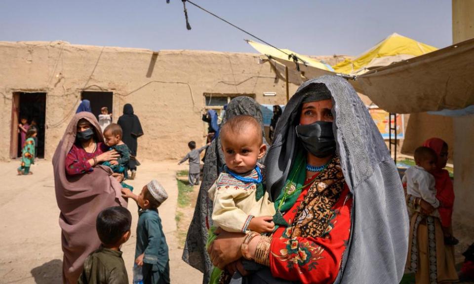 Women and children who fled fighting in Helmand province wait to see a doctor at a mobile clinic