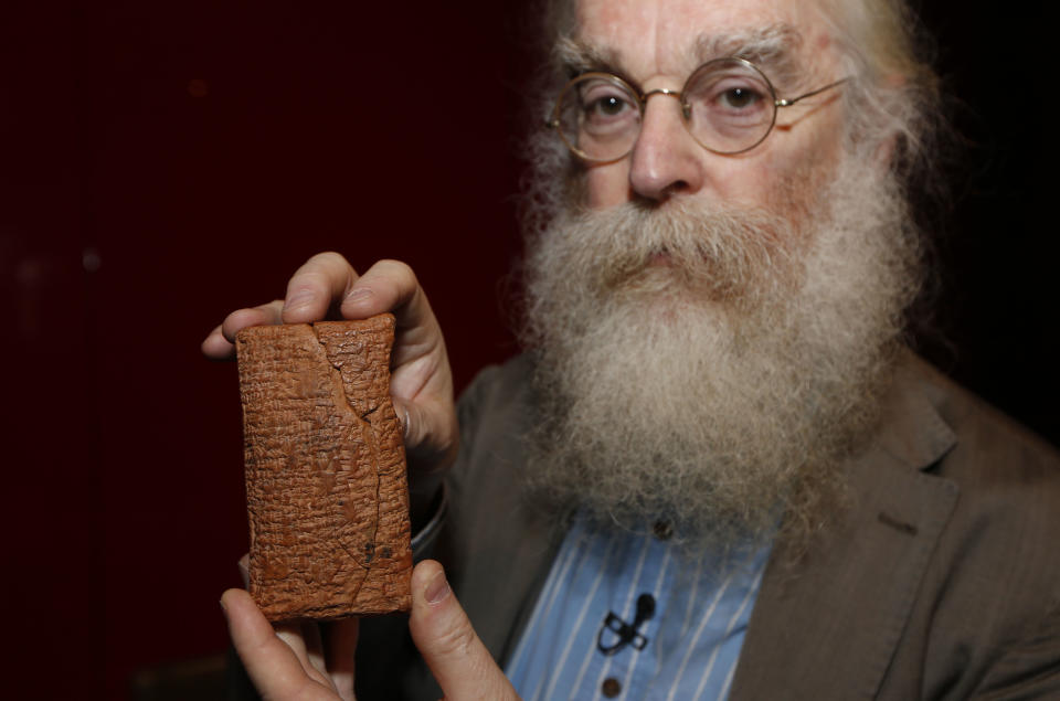 Irving Finkel, curator in charge of cuneiform clay tablets at the British Museum, poses with the 4000 year old clay tablet containing the story of the Ark and the flood during the launch of his book 'The Ark Before Noah' at the British Museum in London, Friday, Jan. 24, 2014. The book tells how he decoded the story of the Flood and offers a new understanding of the Old Testament's central narratives and how the flood story entered into it. (AP Photo/Sang Tan)