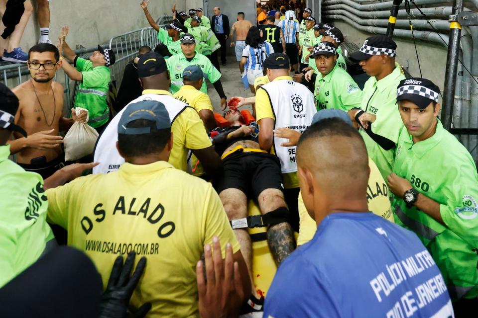 One bloodied fan had to be taken from the stadium on a stretcher (Getty Images)