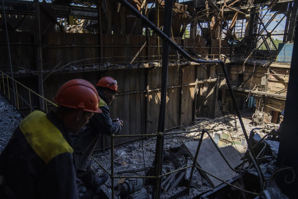 Workers stand next to debris in a damaged DTEK thermal power plant after a Russian attack in Ukraine, Thursday, May 2, 2024. Ukrainian energy workers are struggling to repair the damage from intensifying airstrikes aimed at pulverizing Ukraine's energy grid, hobbling the economy and sapping the public's morale. (AP Photo/Francisco Seco)