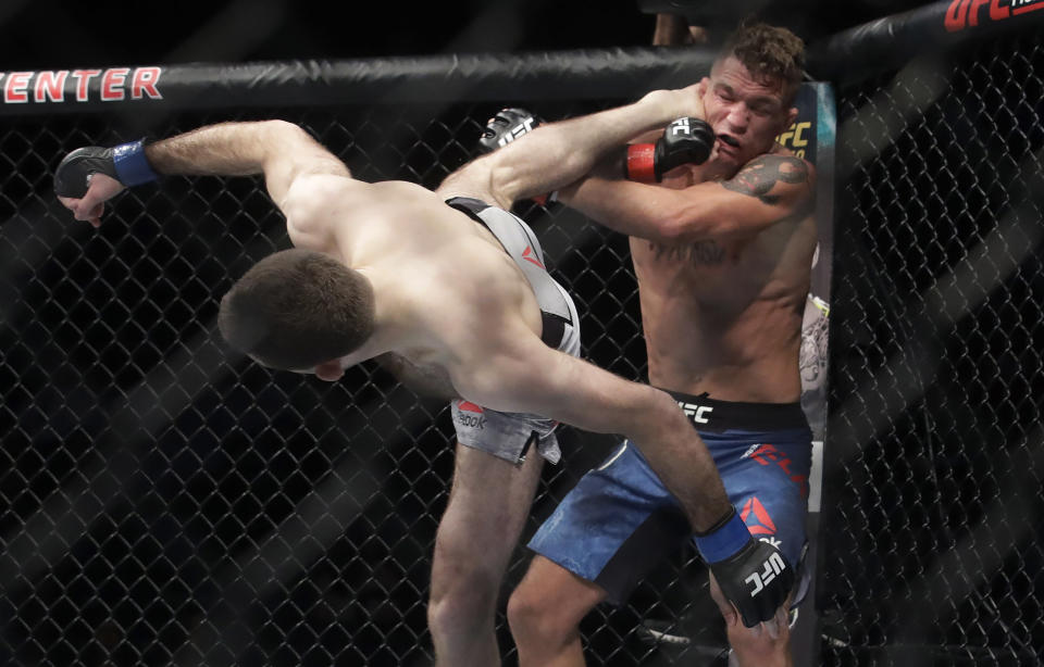 Ryan Hall, left, kicks Darren Elkins during a featherweight mixed martial arts fight at UFC Fight Night in Sacramento, Calif., Saturday, July 13, 2019. Hall won by unanimous decision. (AP Photo/Jeff Chiu)