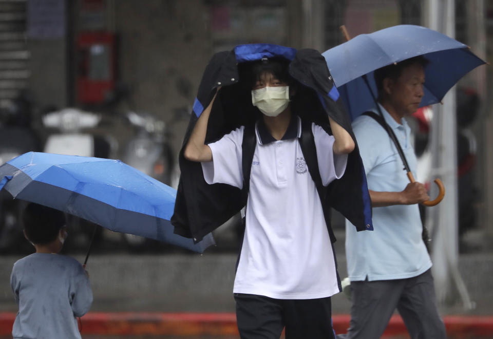 People walk in the rain as Typhoon Koinu approaches to Taiwan in Taipei, Taiwan, Wednesday, Oct. 4, 2023. (AP Photo/Chiang Ying-ying)