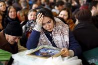 A friend of Zeynep Basak Gulsoy, one of the victims of Sunday's suicide bomb attack, mourns next to her coffin during a funeral ceremony in Ankara, Turkey March 15, 2016. REUTERS/Umit Bektas