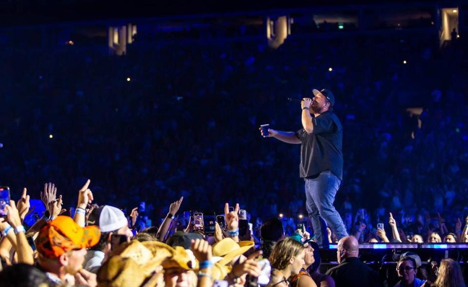 Luke Combs sings out as the crowd cheers at Bank of America Stadium on Saturday, July 15, 2023. There were multiple rain delays because of thunderstorms in the area but the majority of the fans came back to their seats for the show.