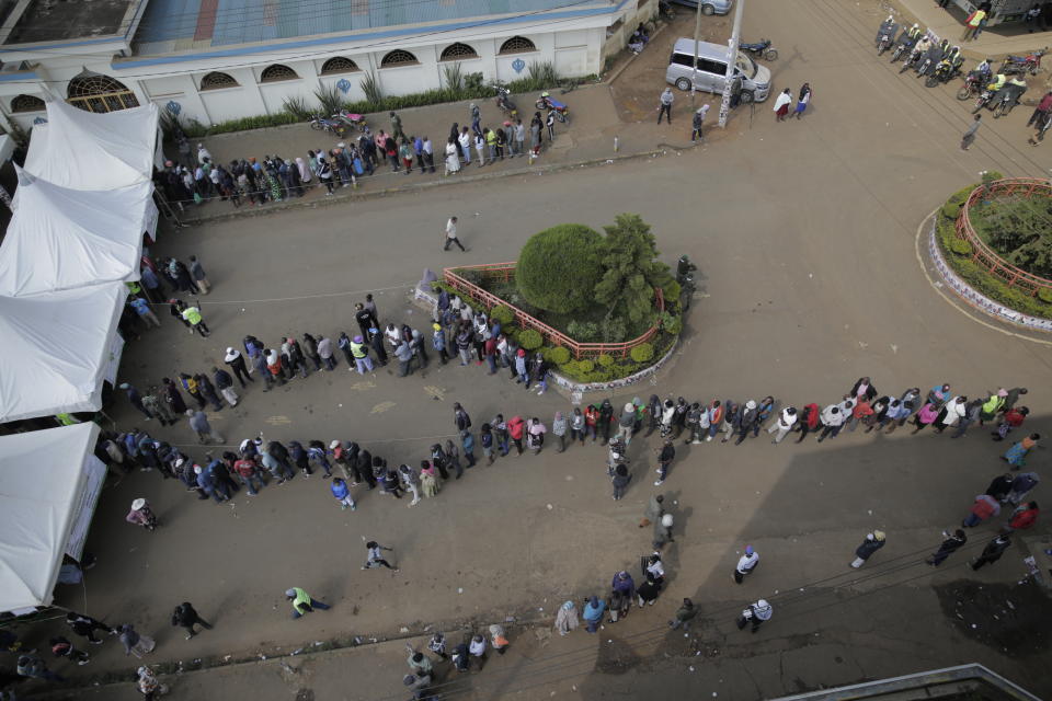 People line up to cast their vote in Kenya's general election in Eldoret, Kenya, Tuesday Aug. 9, 2022. Kenyans are voting to choose between opposition leader Raila Odinga Deputy President William Ruto to succeed President Uhuru Kenyatta after a decade in power. (AP Photo/Brian Inganga))