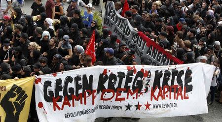 Anti-G7 protestors march during a demonstration in Garmisch-Partenkirchen, southern Germany, June 6, 2015. The Group of Seven (G7) two-day summit, being held at Elmau palace near Garmisch-Partenkirchen in Bavaria, begins on Sunday. The text reads 'Against war and crisis. Fight the capital.' REUTERS/Michaela Rehle