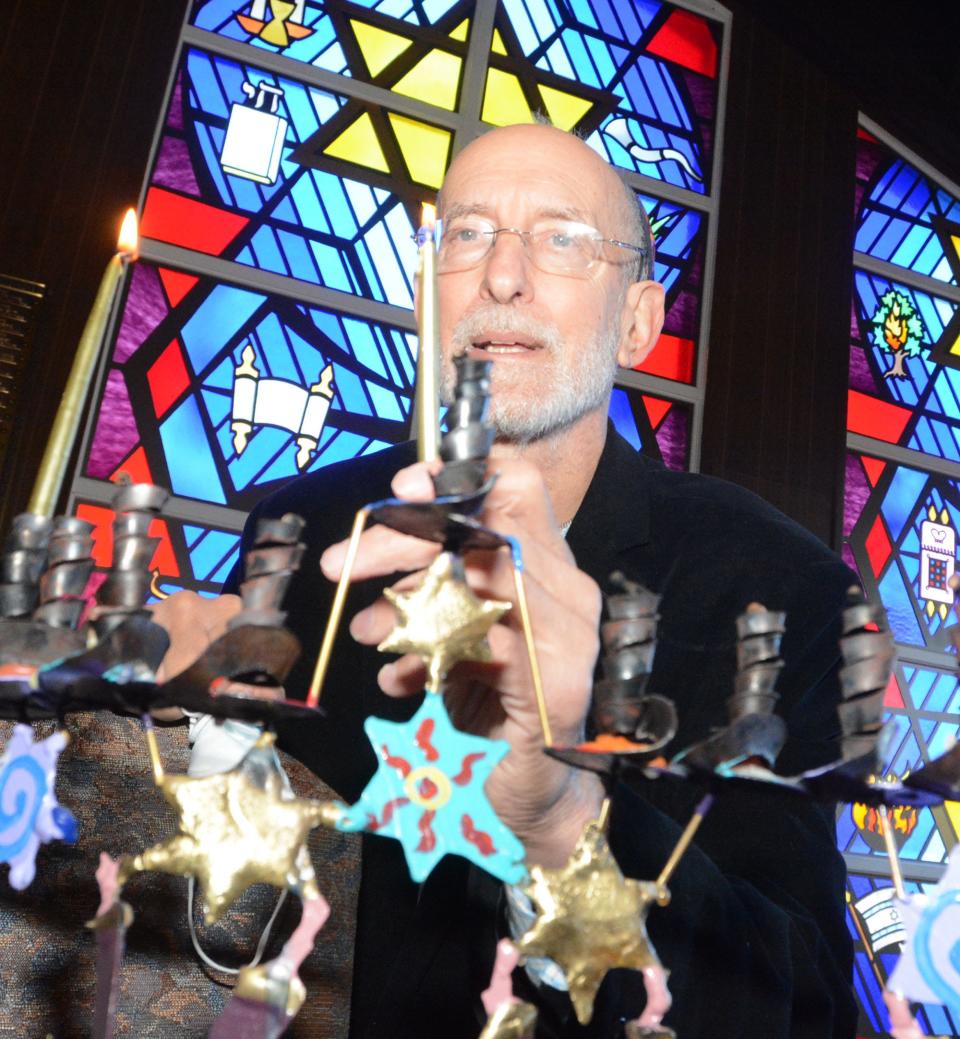 Rabbi Ken Alter lights the first candle of Hanukkah at Congregation Ahavath Achim in Colchester. Rabbi Alter is in his 25th year at the Lebanon Avenue synagogue.