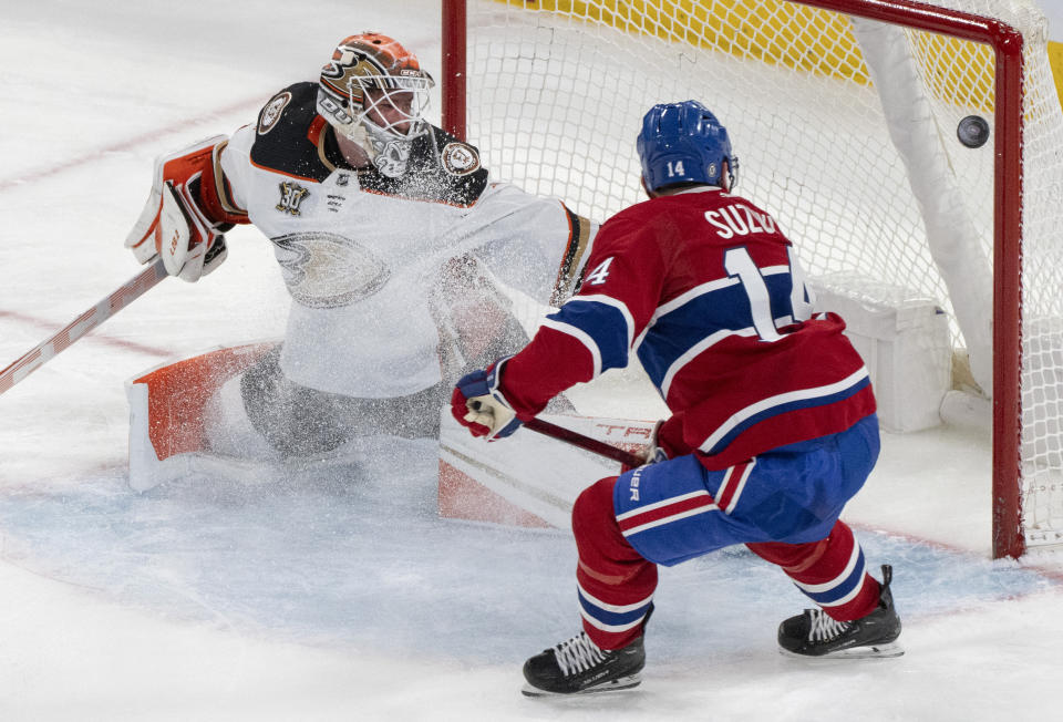 Montreal Canadiens' Nick Suzuki (14) scores on Anaheim Ducks goaltender Lukas Dostal (1) during the second period of an NHL hockey game Tuesday, Feb. 13, 2024, in Montreal. (Christinne Muschi/The Canadian Press via AP)