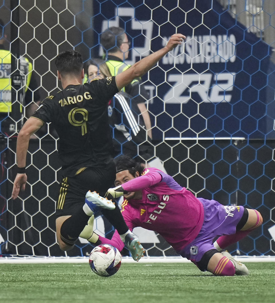 Vancouver Whitecaps goalkeeper Yohei Takaoka, right, stops Los Angeles FC's Mario Gonzalez (9) during the first half in Game 2 of a first-round MLS playoff soccer match in Vancouver, British Columbia, Sunday, Nov. 5, 2023. (Darryl Dyck/The Canadian Press via AP)