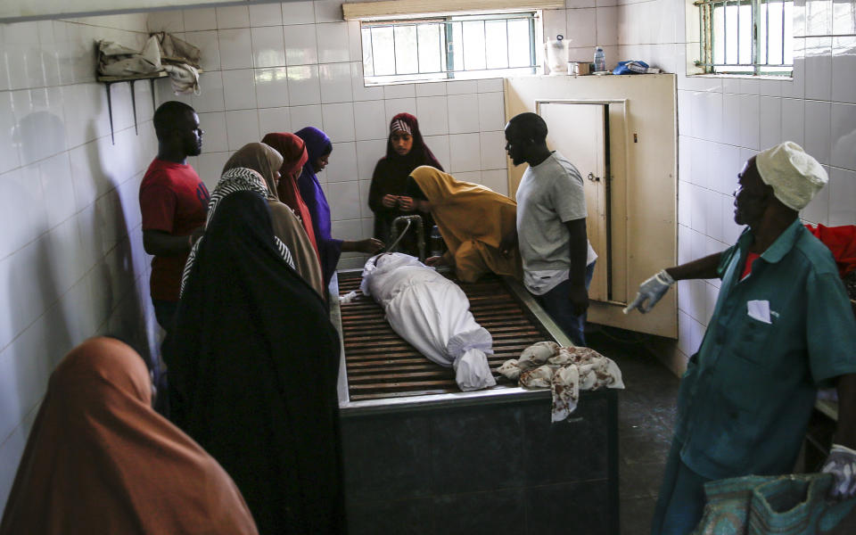 Relatives wash the body of 13-year-old Yasin Hussein Moyo prior to burial, at the Kariakor cemetery in Nairobi, Kenya Tuesday, March 31, 2020. The family of a 13-year-old boy is in mourning after police in Kenya's capital are accused of shooting him dead while enforcing a coronavirus curfew. Kenya’s police inspector general has ordered an investigation into the boy’s death by “stray bullet,” including a forensic analysis of all firearms held by officers at the scene. (AP Photo/Brian Inganga)