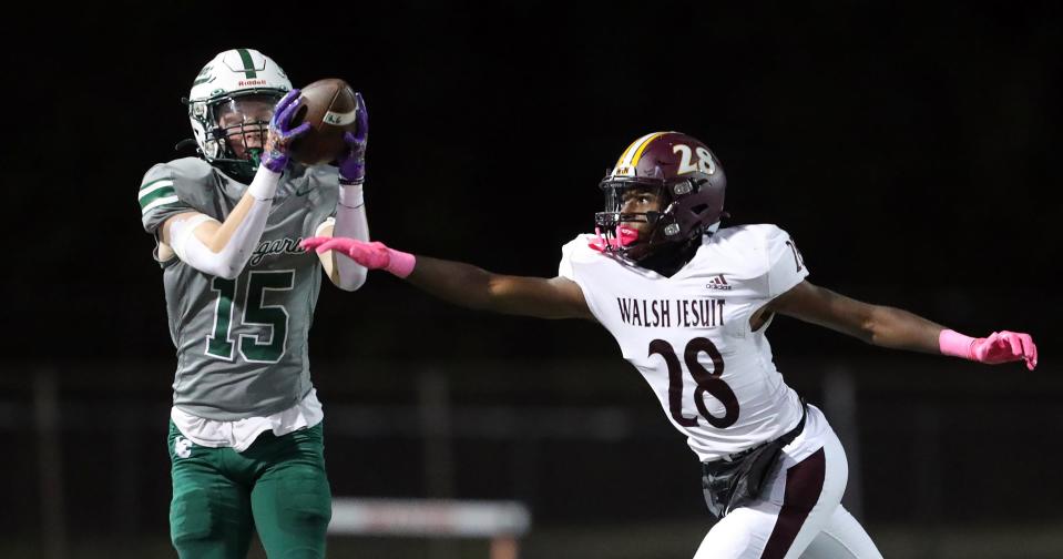 Lake Catholic wide receiver Patrick Radigan, left, catches a pass for first down against Walsh Jesuit defensive back James Brewer during the first half of a high school football game, Friday, Oct. 13, 2023, in Mentor, Ohio.