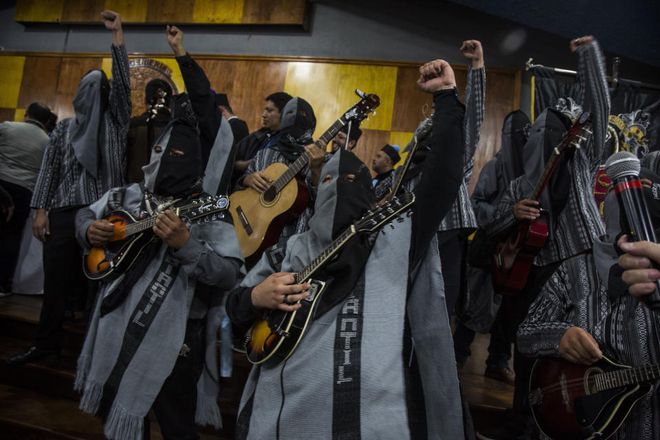 Students of the University of San Carlos wearing hoods, sing protests songs during the ceremony to present Bolivia's president Evo Morales with a Honorary Doctorate, at the University of Guatemala, Thursday, Nov. 15, 2018. Morales is in Guatemala for the XXVI Iberoamerican Summit that is taking place in Antigua. (AP Photo/Oliver de Ros)