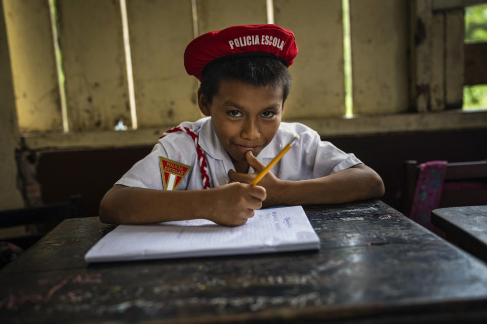 Murui youth Juan Ochoa, a school police officer, sits inside his classroom at the secondary school in Nuevo Arenal, Peru, Tuesday, May 28, 2024. A federal highway project in an untouched area of the Peruvian Amazon is facing mounting opposition from Indigenous tribes, including the Murui. (AP Photo/Rodrigo Abd)