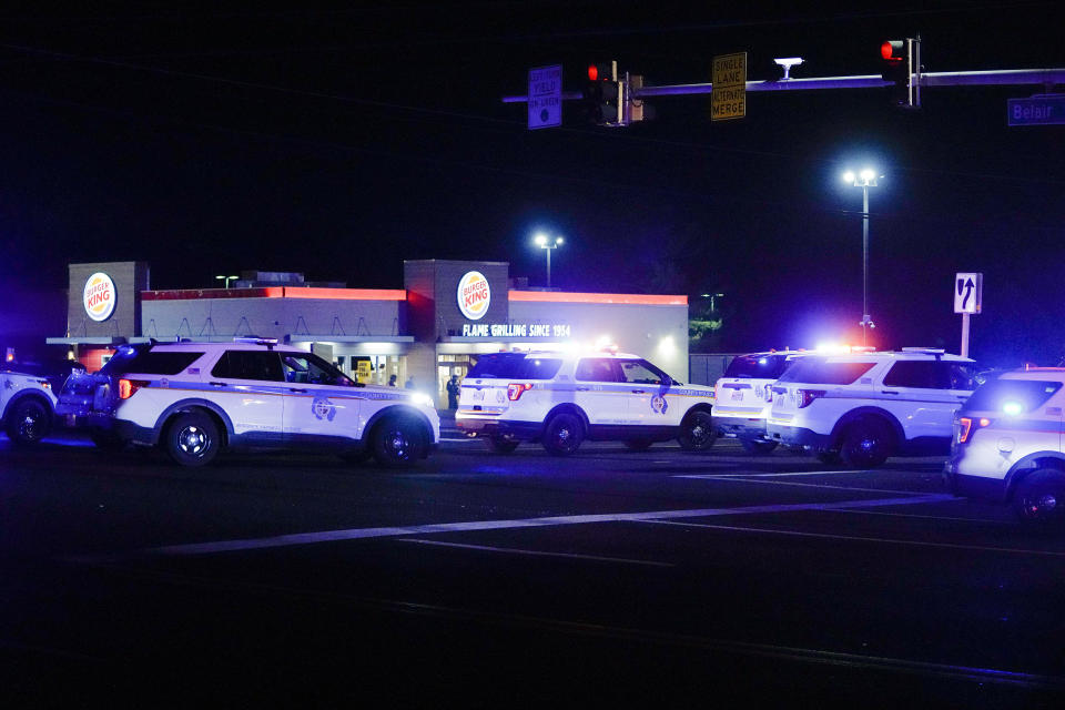 Police vehicles park in formation at an intersection checkpoint on Mountain Road and Belair Road where a suspected gunman is believed to be at large, Thursday, Feb. 9, 2023, in Fallston, Md. A second police officer in Maryland has been injured in gunfire as Baltimore County police continue searching for a suspect amid a large manhunt that began after a different officer was shot Wednesday. (AP Photo/Julio Cortez)