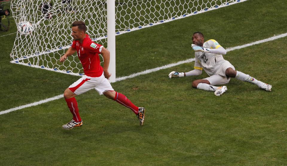 Switzerland's Haris Seferovic (L) scores past Ecuador's Alexander Dominguez during their 2014 World Cup Group E soccer match at the Brasilia national stadium in Brasilia June 15, 2014. REUTERS/David Gray (BRAZIL - Tags: SOCCER SPORT WORLD CUP)