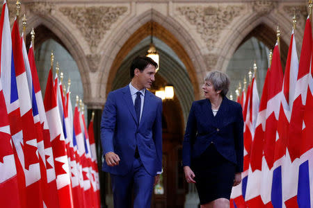 Canada's Prime Minister Justin Trudeau (L) and Britain's Prime Minister Theresa May walk in the Hall of Honour on Parliament Hill in Ottawa, Ontario, Canada, September 18, 2017. REUTERS/Chris Wattie