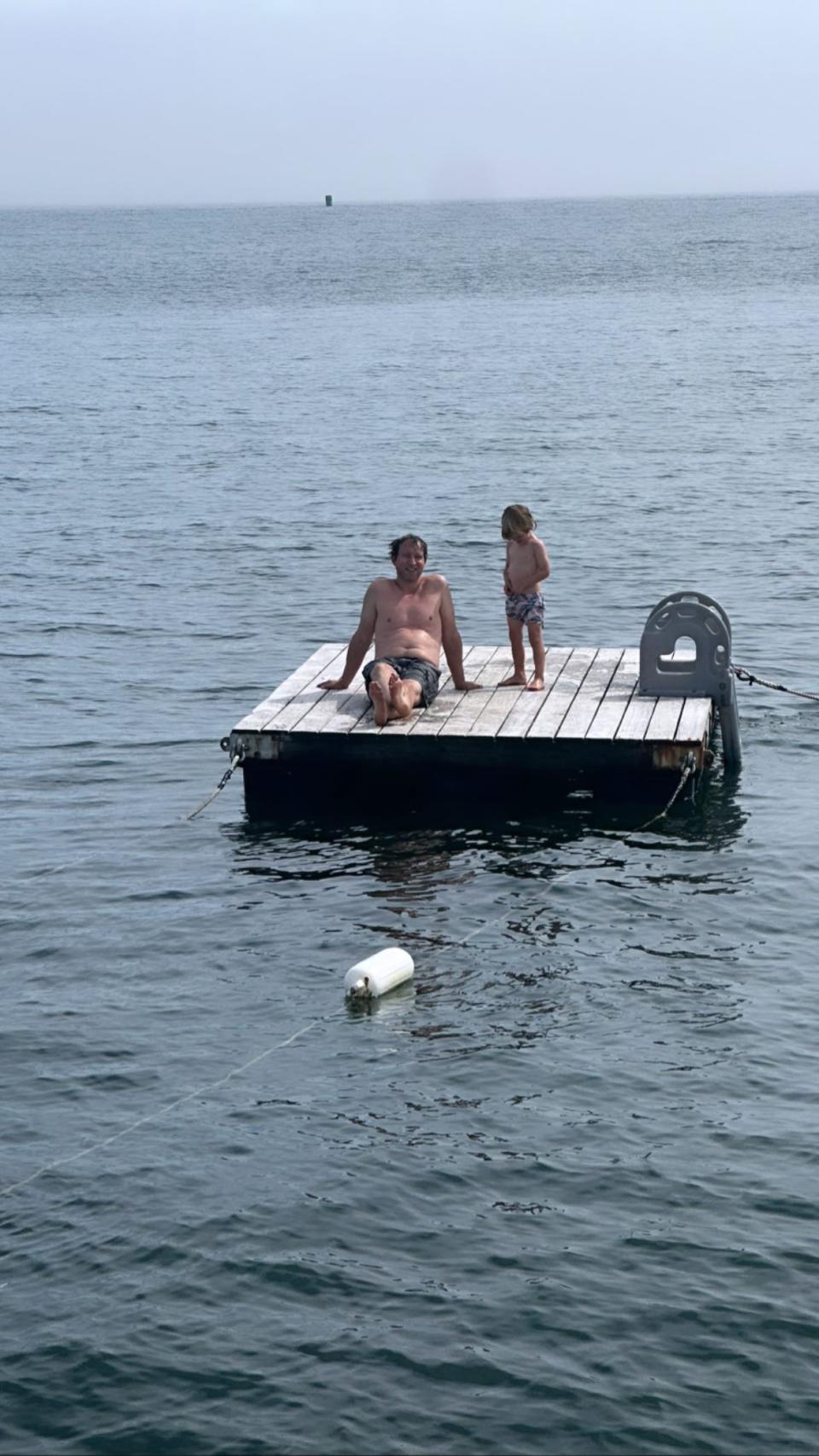 Jenna Bush Hager's husband, Henry, and their son, Hal, relax on a dock after a swim. (@jennabhager via Instagram)