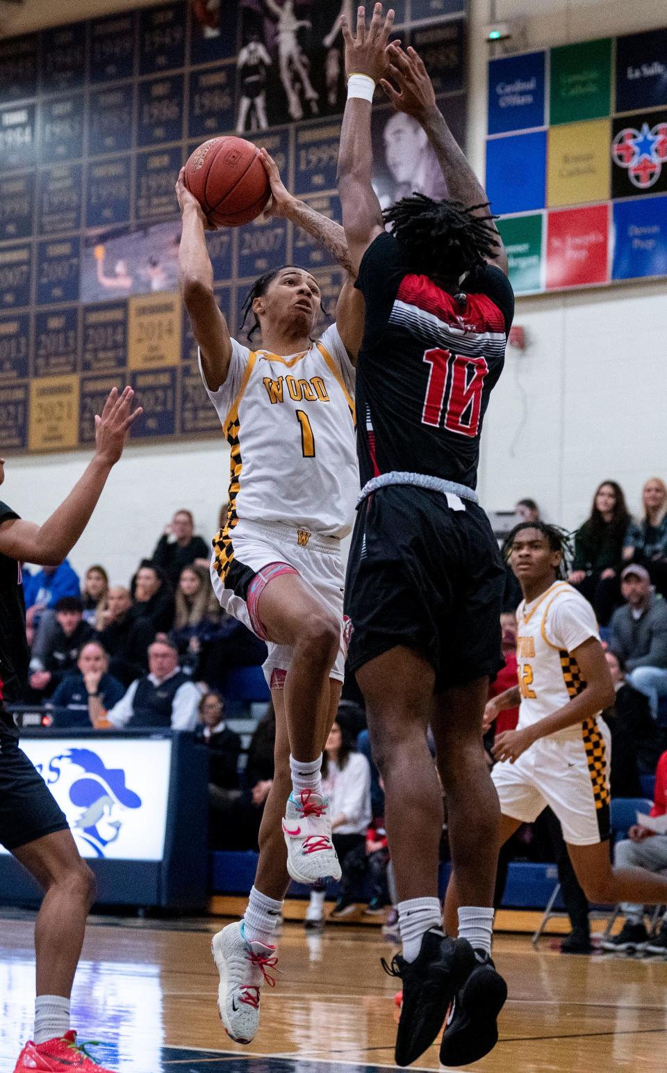 Archbishop Wood's Jalil Bethea (1) gets to the basket against Northeast's Sharif Wallace during Tuesday's District 12 third-place playoff game at La Salle High.