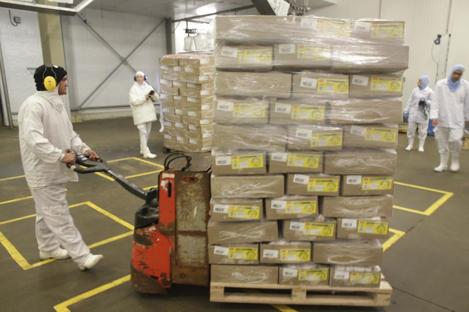 Employees move packaged poultry at meatpacking company JBS, in Lapa, in the Brazilian state of Parana, Tuesday, March 21, 2017. Brazil's president said Tuesday that a scandal over sale of expired meat is an "economic embarrassment". On Tuesday, Hong Kong's Center for Food Safety announced that it would temporarily suspend imports of frozen and chilled meat and poultry from Brazil, starting immediately, in response to Brazilian investigators charges that health inspectors were bribed to overlook the sale of expired meats. (AP Photo/Eraldo Peres)