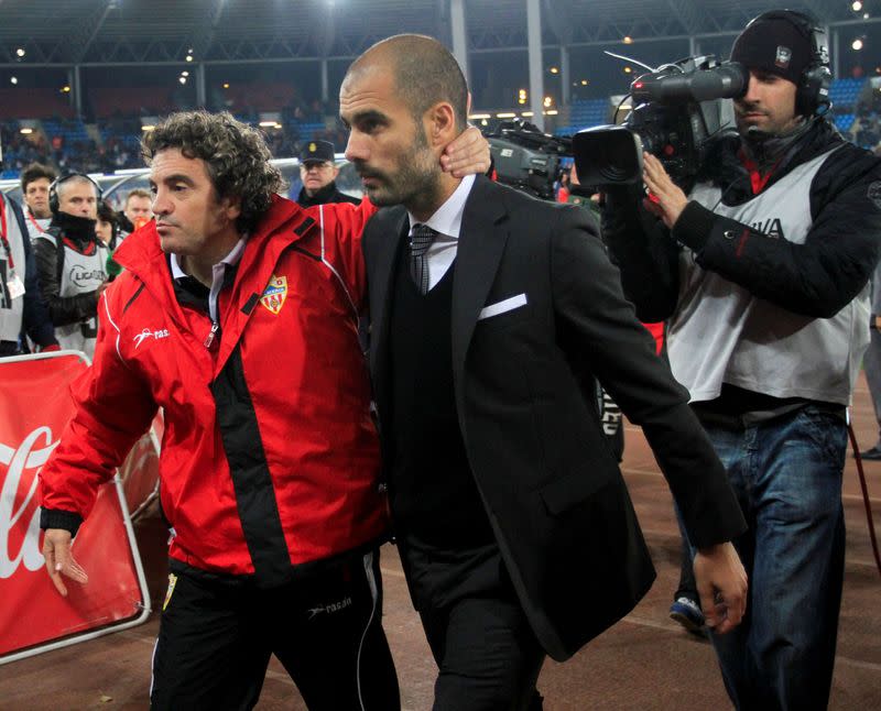 FILE PHOTO: Almeria's coach Lillo and Barcelona's coach Guardiola leave the pitch at the end of their Spanish first division soccer match against Barcelona in Almeria.